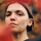 A woman with short brown hair and two silver hoop earrings in her ear